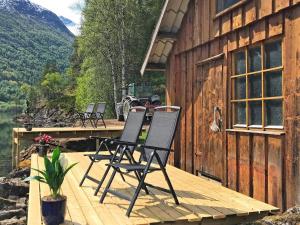 duas cadeiras sentadas num deque ao lado de um edifício em Holiday home STRYN III em Stryn