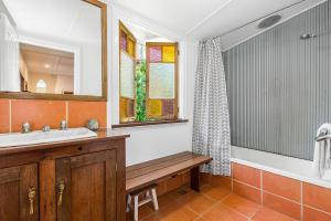 y baño con lavabo, bañera y espejo. en A Perfect Stay - Byron Surf Cottage, en Byron Bay