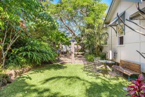 a yard with a bench and a table and chairs at A Perfect Stay - Byron Surf Cottage in Byron Bay