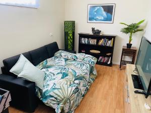 een woonkamer met een bank en een boekenplank bij Tuncurry tranquility PID -STRA - 59456 in Tuncurry