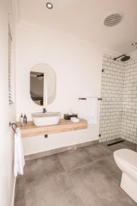 a bathroom with a sink and a mirror at The Corner House L'A-nnexe in Franschhoek +9 photos