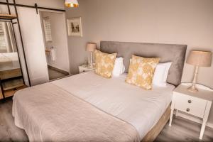 a bedroom with a large bed with white sheets and pillows at The Corner House L'A-nnexe in Franschhoek