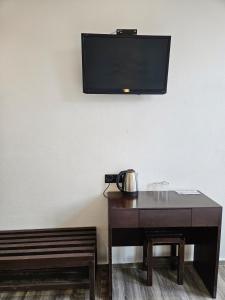Camera con tavolo e TV a parete di Georgetown Inn by Sky Hive a George Town