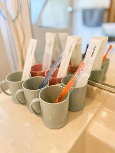 a group of cups sitting on a counter with toothbrushes at Izu Serenity Fuji-View Retreat with Private Onsen in Izu