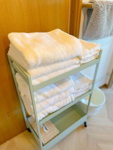 a stack of towels on a shelf in a room at Izu Serenity Fuji-View Retreat with Private Onsen in Izu