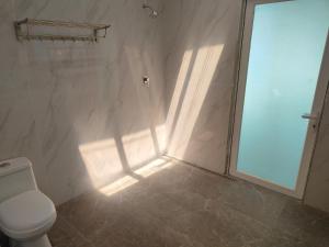 łazienka z prysznicem, toaletą i oknem w obiekcie GreenHouse EcoLodge w mieście Mantanani Island