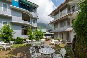 a patio with tables and chairs in front of a building at Spring Valley Resorts by DLS Hotels in McLeod Ganj