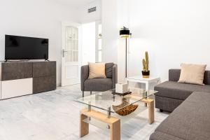 - un salon avec un canapé et une télévision dans l'établissement Estación RooMalaga by Bossh Apartments, à Malaga