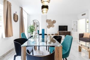 une salle à manger avec une table et des chaises en verre dans l'établissement Estación RooMalaga by Bossh Apartments, à Malaga