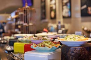 ein Buffet mit Speisen auf dem Tisch in der Unterkunft Grand Noble Hotel Dongguan in Dongguan