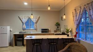 uma cozinha com uma ilha com bancos de bar em Le Petit Guesthouse em Bloemfontein