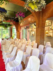 a room with rows of white chairs and flowers at PATIO BUENDIA FARM RESORT AND EVENTS PLACE in Amadeo