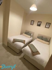 a bedroom with two beds and a light fixture at Scenery Senary by Sheryl - Large house, Right in Town Centre, Near Northampton Gen Hospital in Northampton