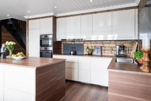 een keuken met witte kasten en houten vloeren bij Løvsangeren 1,5 hour from Oslo - 6 bedrooms - 14 sleeps - Sauna in Nordset