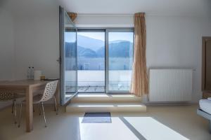 ein Wohnzimmer mit einem Tisch und einem großen Fenster in der Unterkunft Andrian Residence in Andrian