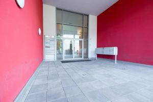 an empty room with a red wall and a building at Andrian Residence in Andrian