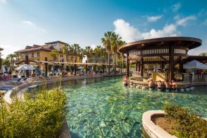 una piscina in un resort con persone sedute in esso di CLUB GRAND AQUA a Side