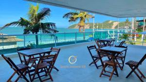 a restaurant with tables and chairs and the ocean at Ponta Negra Beach beira-mar in Natal +30 photos