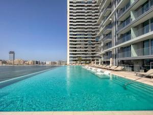 a large swimming pool next to a large building at Sea view 2-Bedroom - Beach Isle in Dubai