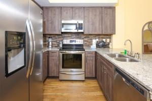 a kitchen with stainless steel appliances and wooden cabinets at Tidewater 1202 condo in Orange Beach +37 photos