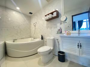 a white bathroom with a tub and a toilet and a sink at A25 Hotel - 20 Bùi Thị Xuân in Ho Chi Minh City