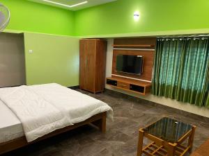 une chambre avec un lit et une télévision à écran plat dans l'établissement Shreesham Resort at Malpe Beach, à Udupi 11 autres photos