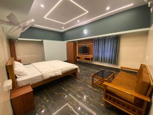 une chambre avec un lit et une télévision dans l'établissement Shreesham Resort at Malpe Beach, à Udupi