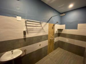 une salle de bain avec lavabo et douche dans l'établissement Shreesham Resort at Malpe Beach, à Udupi