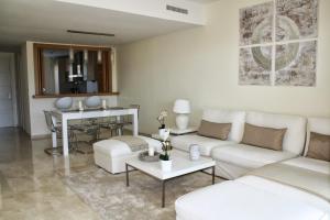 a living room with a white couch and a table at La Cala Golf Townhouse in La Cala de Mijas