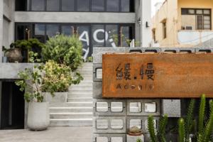 a sign in front of a building with potted plants at 緩慢大鵬灣 in Donggang