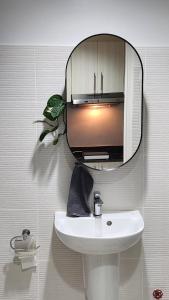 a mirror above a white sink in a bathroom at The New Villa at Sea Residences in Manila +28 photos