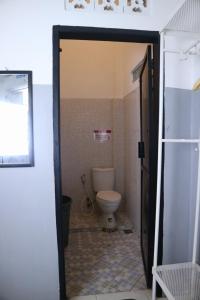 a bathroom with a toilet and a open door at 360 Homestay Padang in Kampungdurian