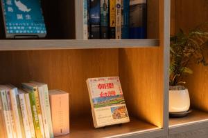 a book shelf filled with books and a book at 緩慢大鵬灣 in Donggang