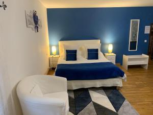 1 dormitorio azul con 1 cama y 1 silla en Chambres d'Hôtes Au Clos Saint Georges, en Saint-Jory