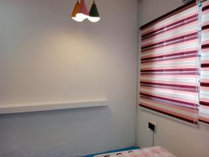 una habitación con una pared con rayas de colores en Room 1 (Super single: 1 pax), en Kampong Kiarong