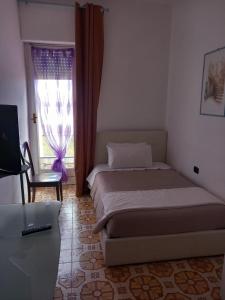 1 dormitorio con cama, ventana y escritorio en Il Brindisi di C & C Castelli Romani, en Pomezia