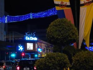 una calle de la ciudad por la noche con un edificio con luces azules en Room 1 (Super single: 1 pax), en Kampong Kiarong