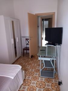 1 dormitorio con 1 cama y escritorio con TV en Il Brindisi di C & C Castelli Romani, en Pomezia