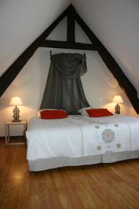 a bedroom with a large white bed in a attic at Ferme Saint Christophe in Saint-Marcan