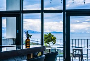 a room with a table with chairs and a view of the ocean at 緩慢大鵬灣 in Donggang