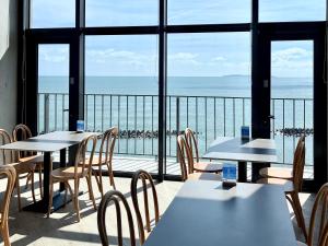 a restaurant with tables and chairs and a view of the ocean at 緩慢大鵬灣 in Donggang