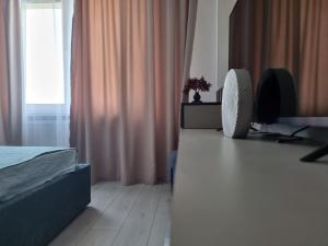 基輔的住宿－Квартира з неймовірним краєвидом，一间卧室配有一张床、一张书桌和一个窗户。