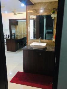 a bathroom with a sink and a large mirror at Vaishnavi furnished flats in Mangalore