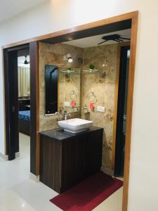 a bathroom with a sink and a mirror at Vaishnavi furnished flats in Mangalore