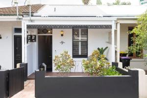 a white house with a black fence in front of it at Richmond Sanctuary in Melbourne