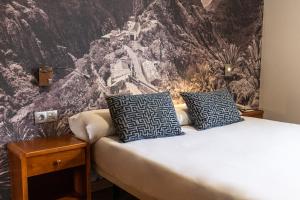 a bedroom with a bed with blue and white pillows at Hotel Adonis Plaza in Santa Cruz de Tenerife