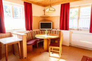 ein Wohnzimmer mit einem Tisch und einem TV in der Unterkunft Knollgut Ferienwohnung Buchberg in Goldegg