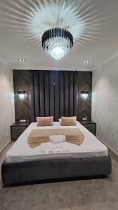 a bedroom with a large bed and a chandelier at Sharq hotel in Urganch