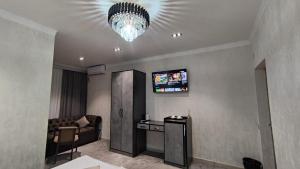 un soggiorno con divano e lampadario pendente di Sharq hotel a Urganch