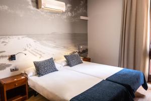 a bedroom with a bed and a painting of a beach at Hotel Adonis Plaza in Santa Cruz de Tenerife